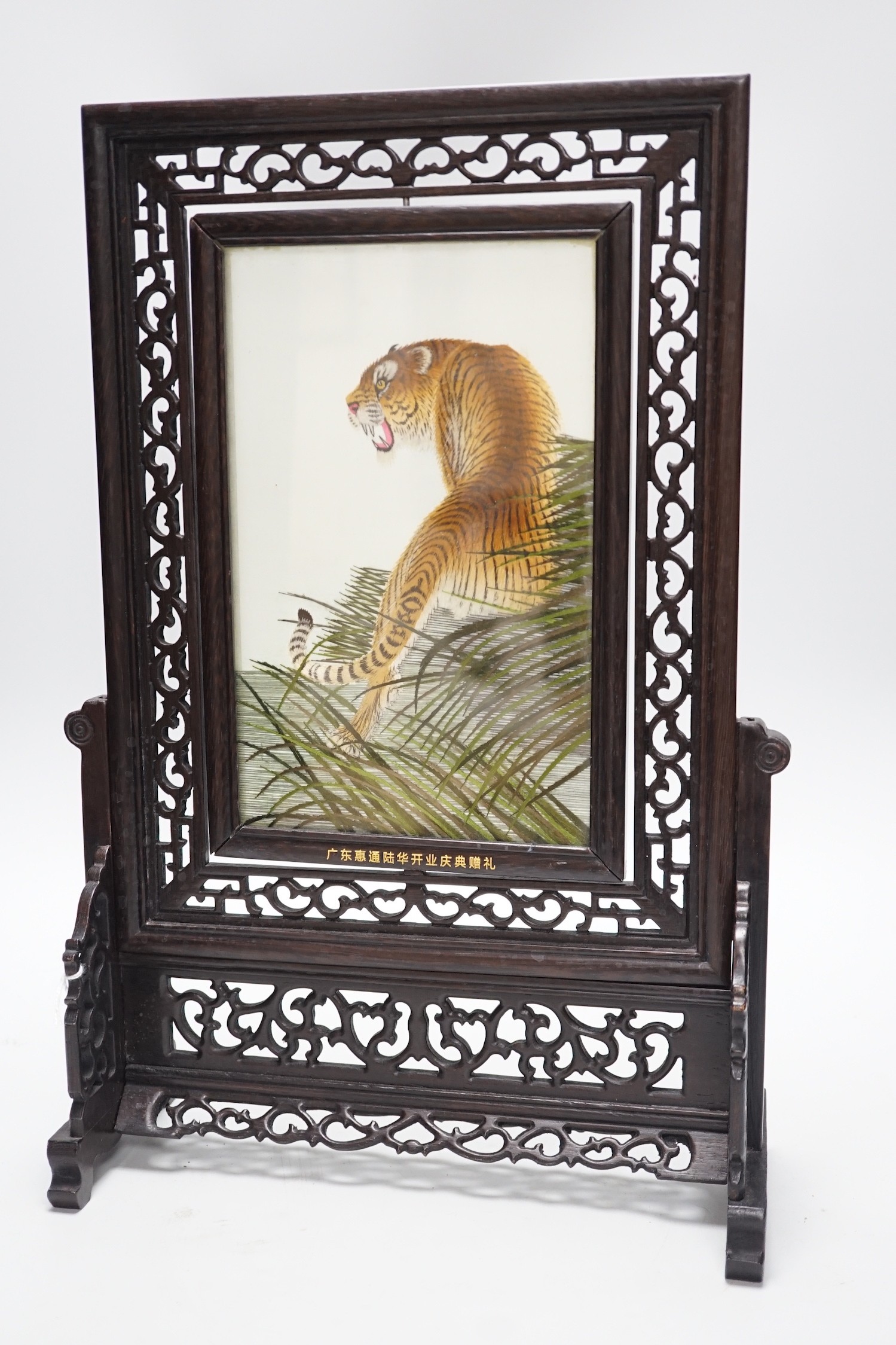 A Chinese reversible silk embroidered panel of a tiger in a revolving screen and hardwood carved frame, 45cms high